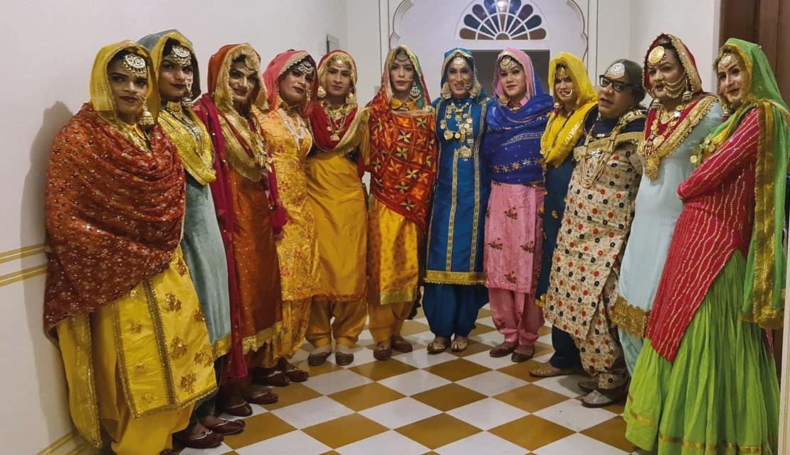 The troupe, dressed in colourful gowns, pose for a photograph