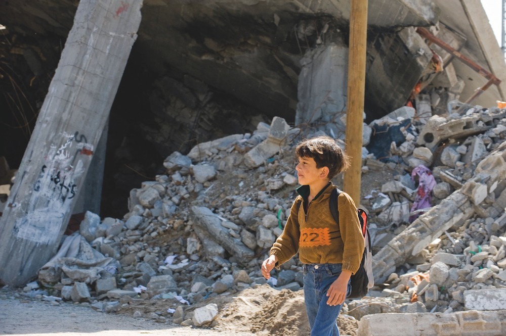 A child in Gaza leaves school surrounded by rubble, following Israeli strikes in 2009