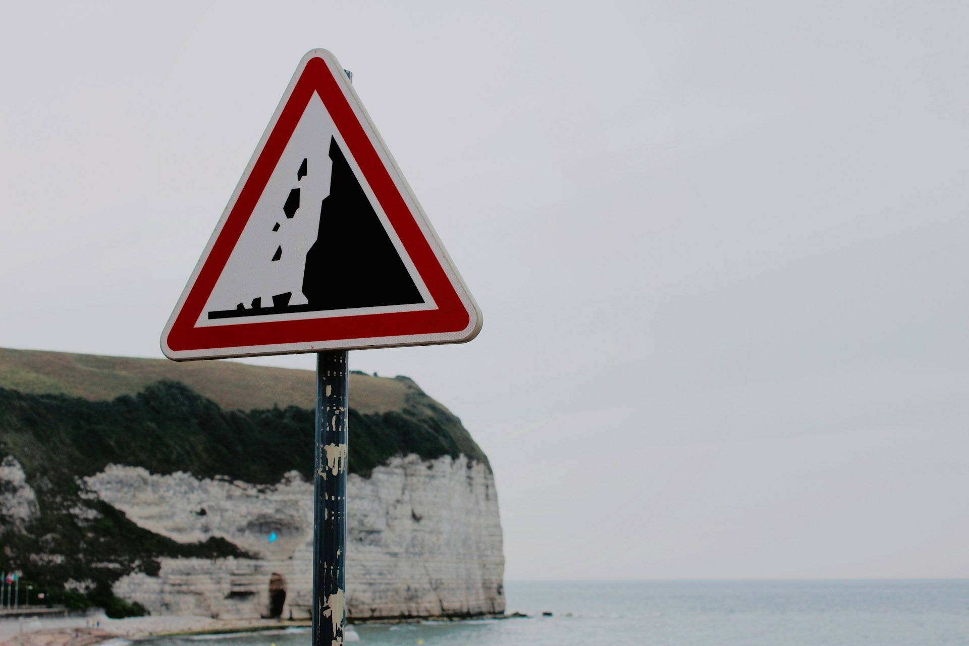 A sign warns of possible rockfall near cliffs in France