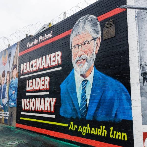 A portrait of Gerry Adams painted on a wall in Belfast, with the words 'Peacemaker, Leader, Visionary'