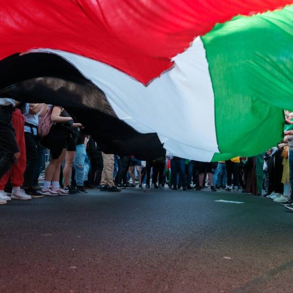 Protesters stand around a huge Palestinian flag during a protest in London