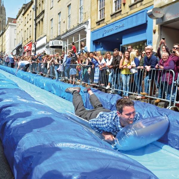 Adults play on a waterslide