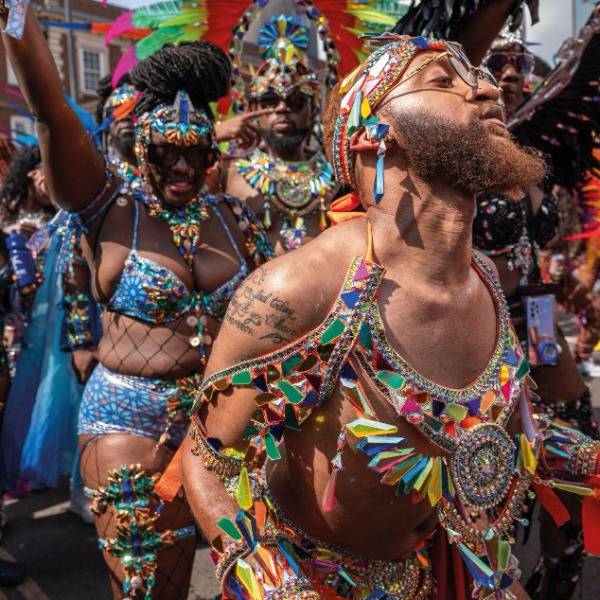 A crowd of revellers in brightly-coloured clothing at the Notting Hill Carnival