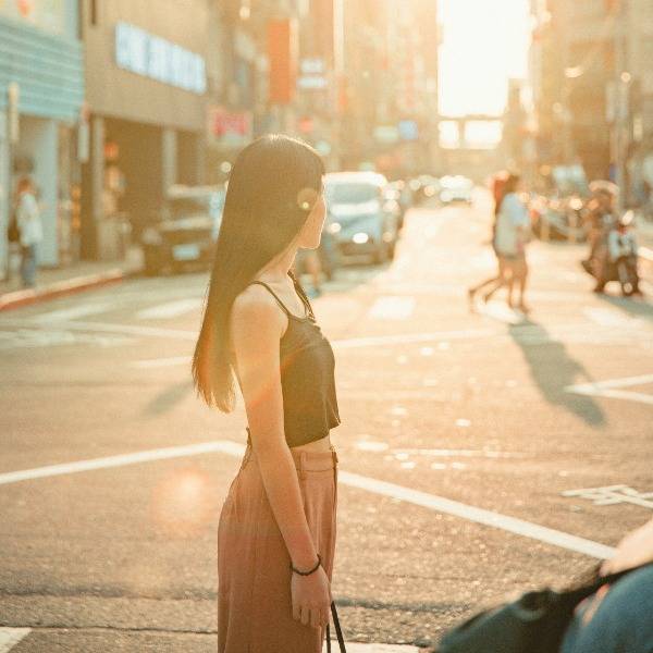 A woman stands in the middle of a busy road