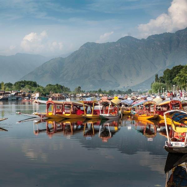 Yellow boats on Dal Lake in Srinagar, with mountains in the background