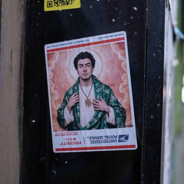 A sticker depicting Luigi Mangione as a religious figure, seen stuck to a building in Glasgow, Scotland