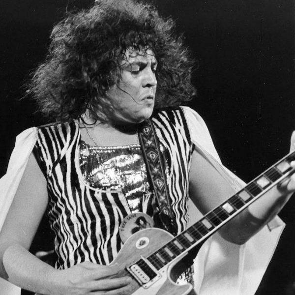 A black and white photo of Marc Bolan on stage in 1973