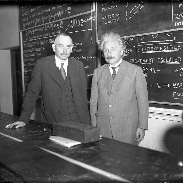 Albert Einstein photographed in front of a blackboard covered in writing, alongside American physicist Richard C Tolman