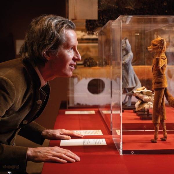 Wes Anderson looks at a model of Mr Fox displayed at the retrospective