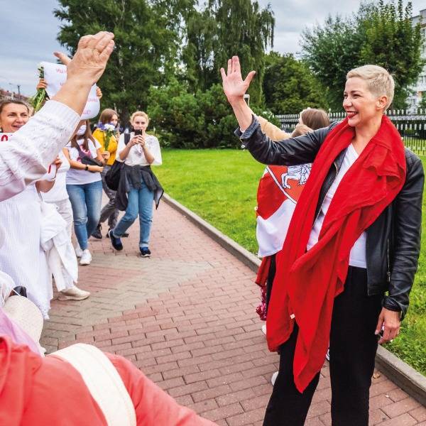 Belarusian political activist Maria Kolesnikova, wearing her signature red lipstick and a bright red scarf, waves to supporters