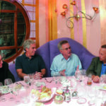 Epstein sits at a restaurant table with three other men, during a dinner he hosted at Harvard in 2004