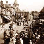 A sepia image of people walking through Pickering market place in Yorkshire, 1930s