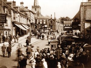 A sepia image of people walking through Pickering market place in Yorkshire, 1930s