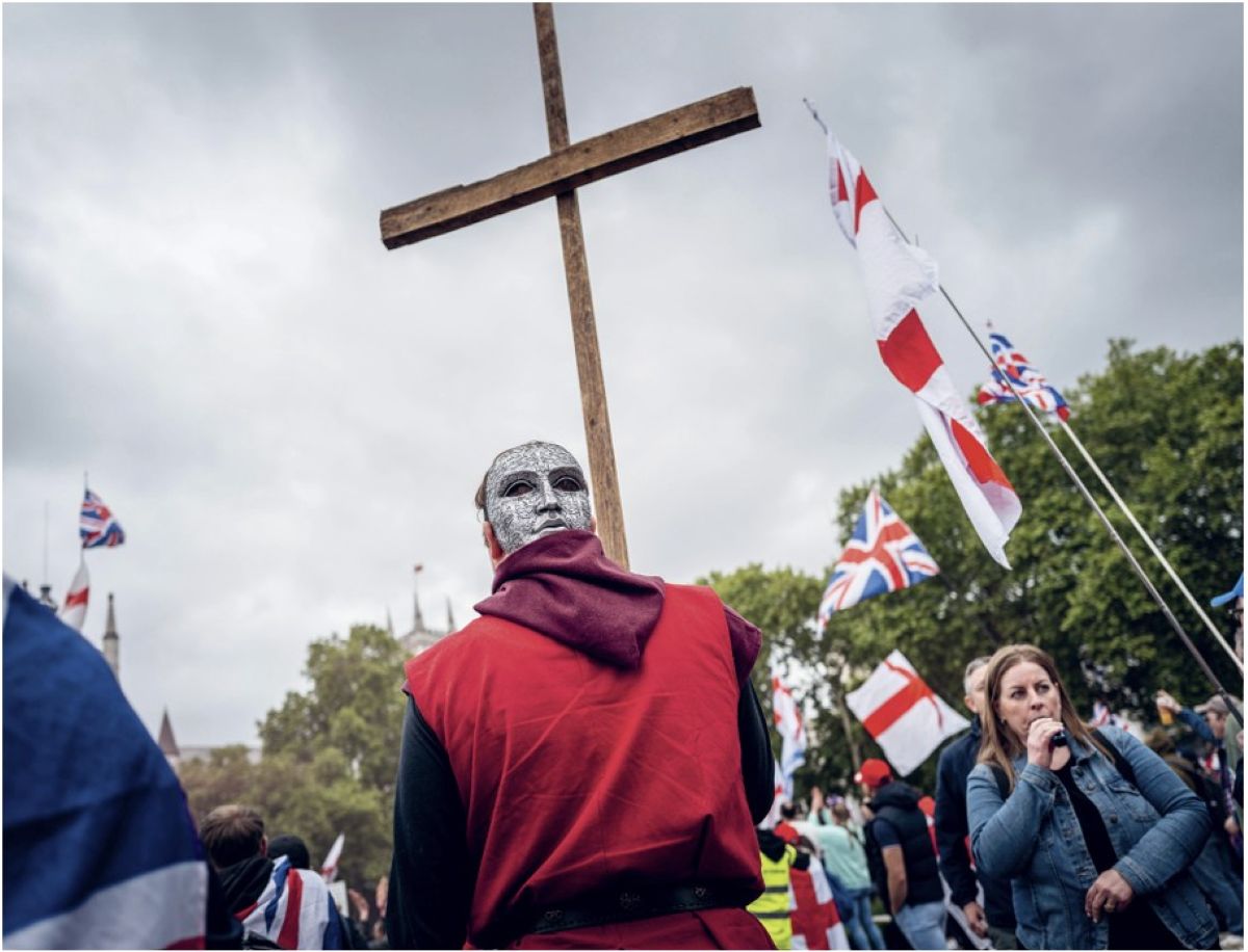 A man holds a cross at Tommy Robinson’s Unite the Kingdom rally in central London, May 2026
