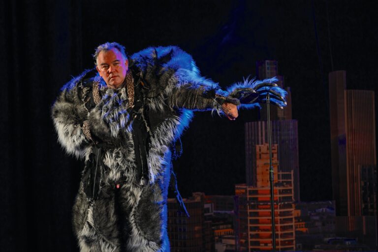 Stewart Lee on stage dressed in a werewolf costume