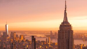 The New York City skyline against an orange sky