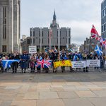 People hold up signs reading "Protect our women" and "Locals before illegals" at an anti-immigration protest in Aberdeen