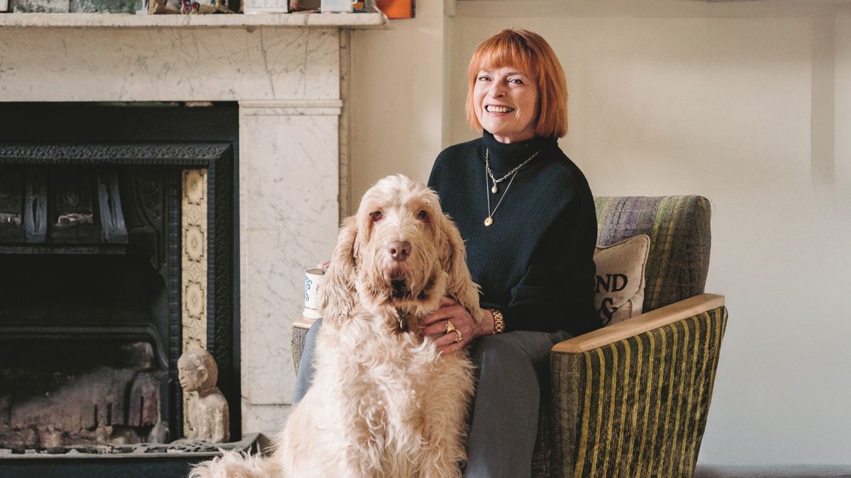 A photo of Janet Ellis sitting on a sofa with her dog