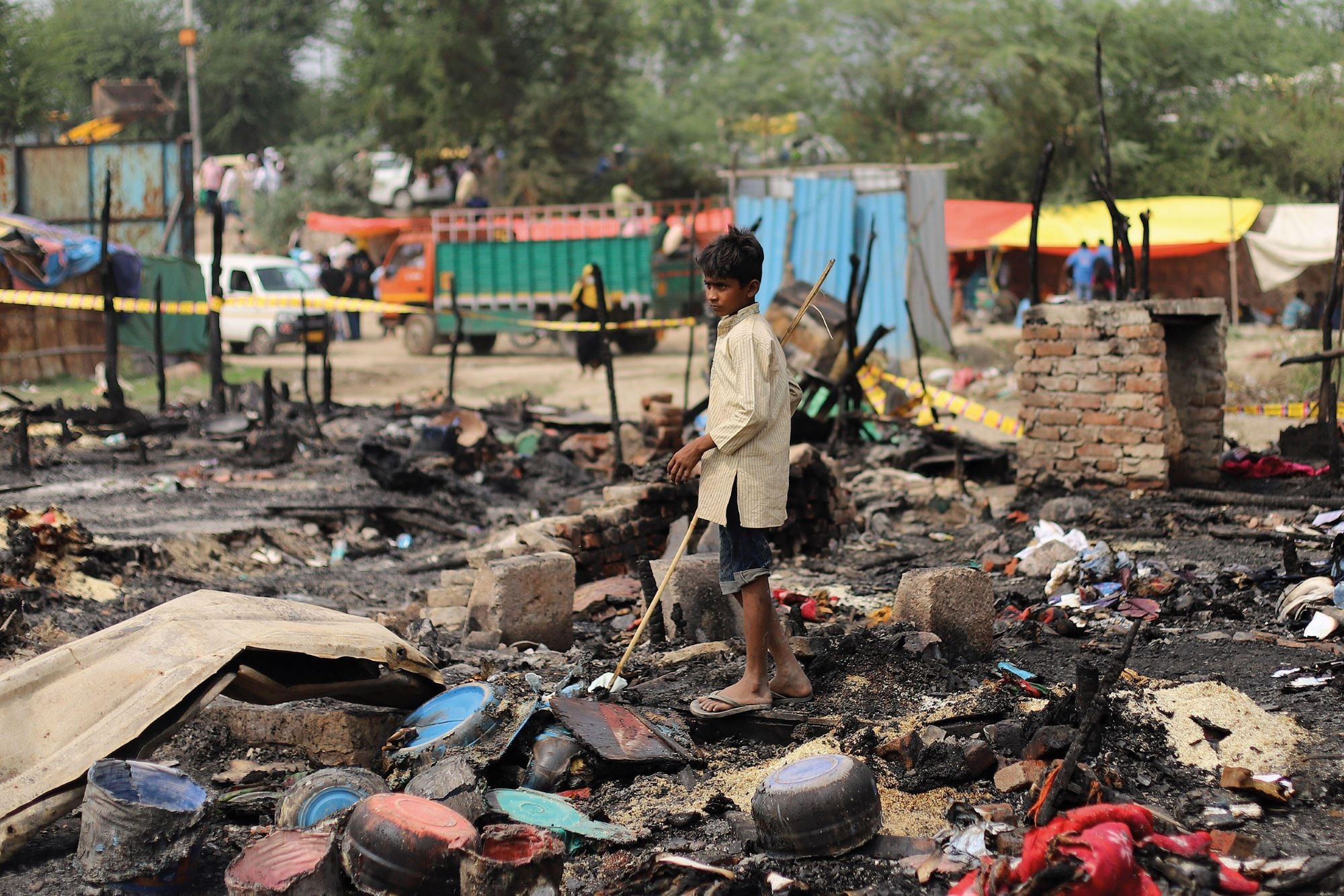 A young boy searches for his belongings after a fire at a Rohingya refugee camp in New Delhi in June 2021