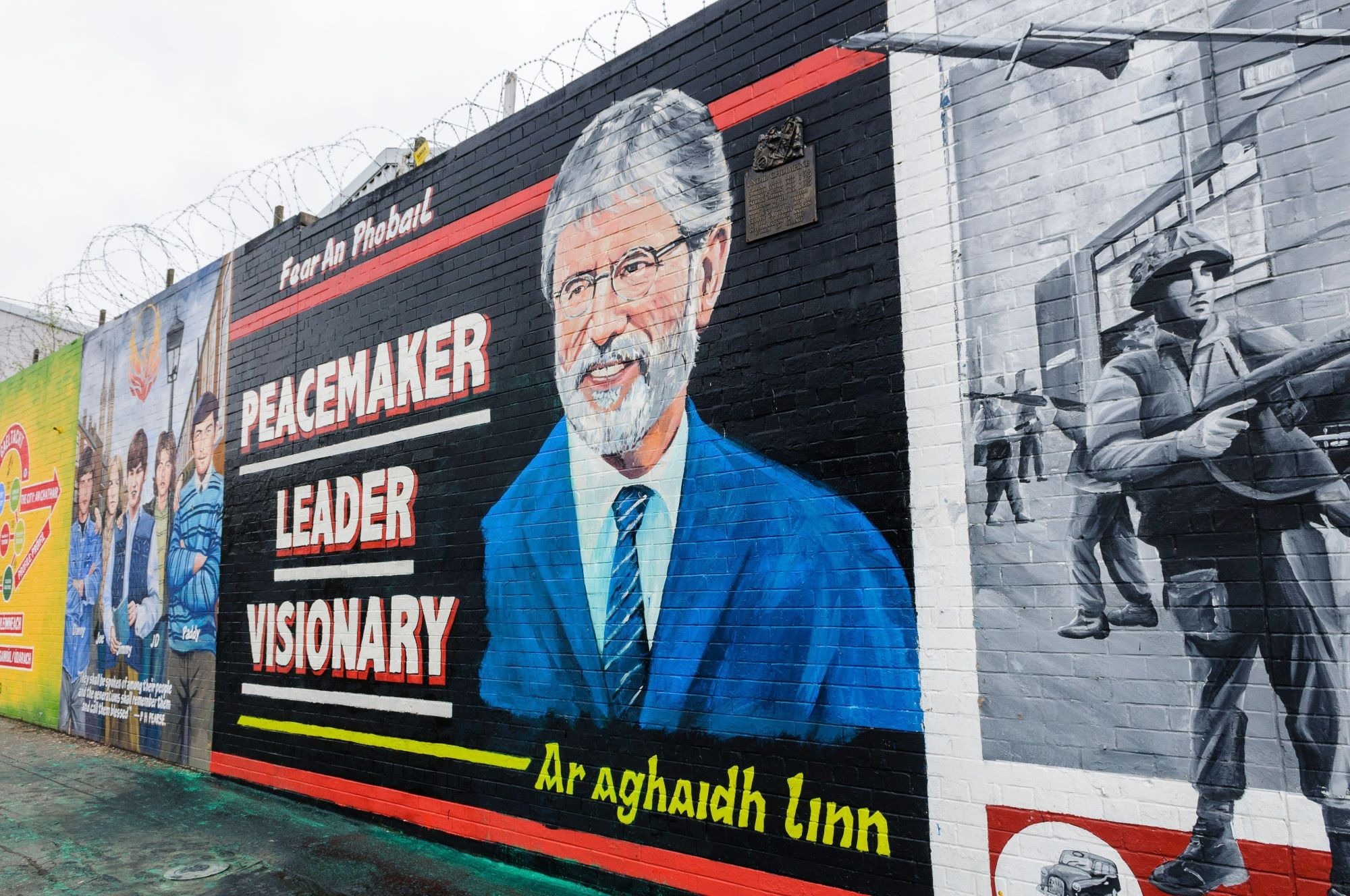 A portrait of Gerry Adams painted on a wall in Belfast, with the words 'Peacemaker, Leader, Visionary'