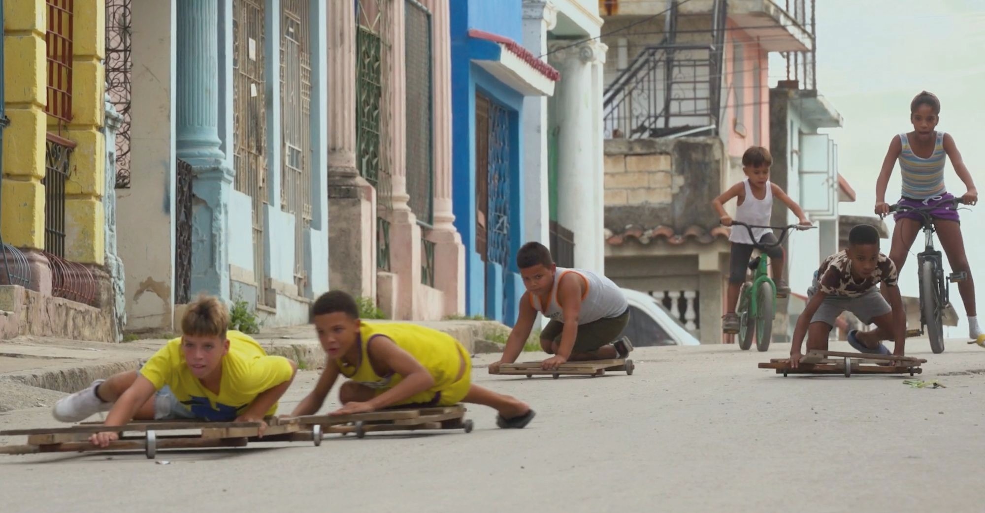In a still from the “Children’s Games” series, children in Havana, Cuba play 'chivichanas', skating perilously down a hill on makeshift sledges
