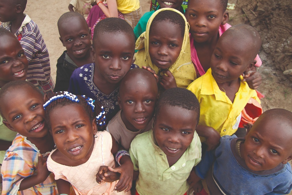 A crowd of young pupils at a humanist school in Uganda look up to the camera
