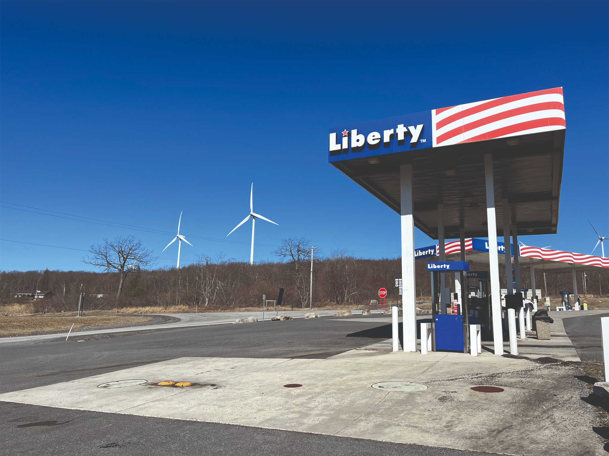 A photo shows a gas station with wind turbines behind it in Mount Storm