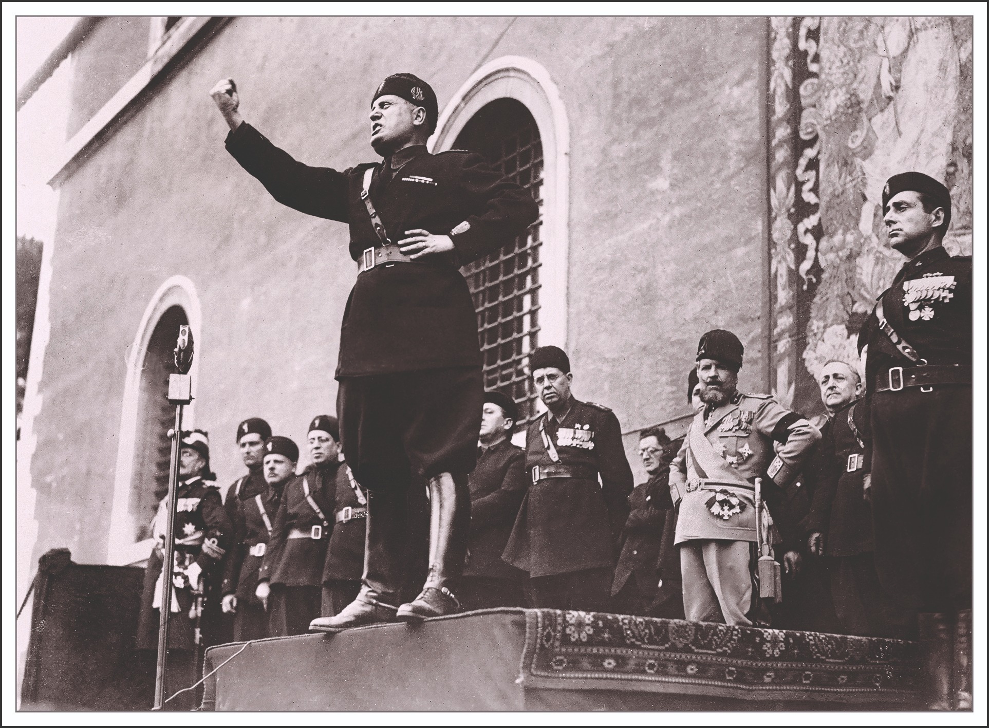 Benito Mussolini stands on a podium in 1935