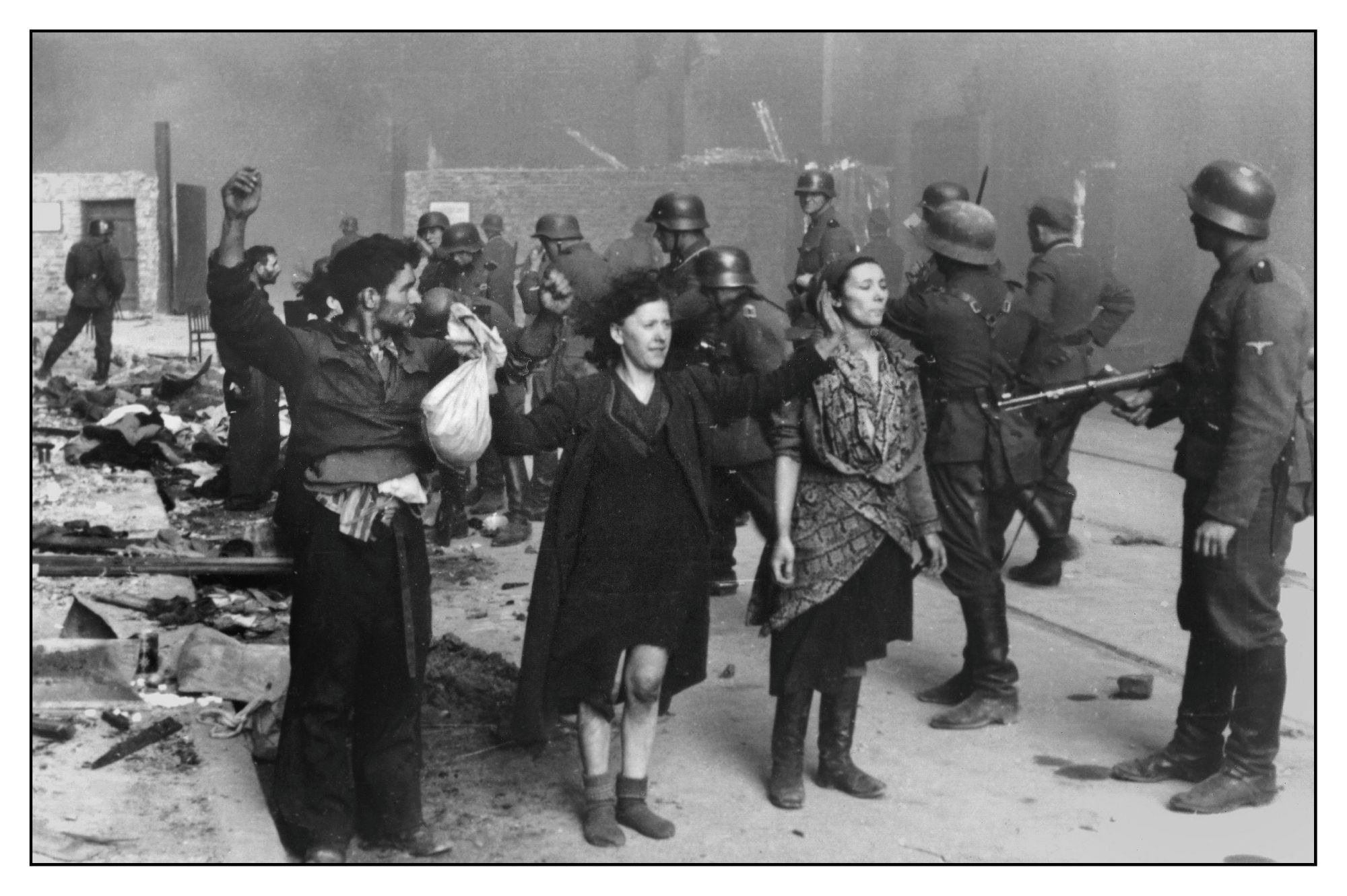 Polish Jews stand in defiance of the Nazi troops in the Warsaw Ghetto, 1943