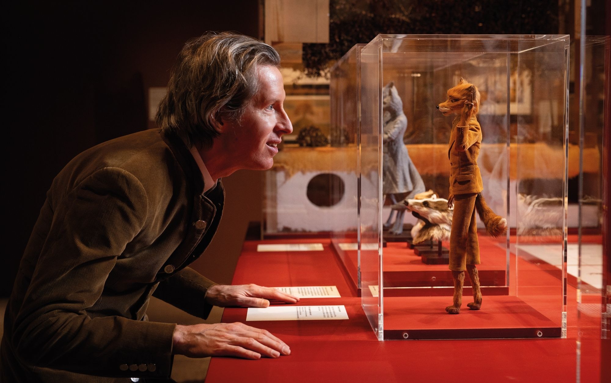 Wes Anderson looks at a model of Mr Fox displayed at the retrospective