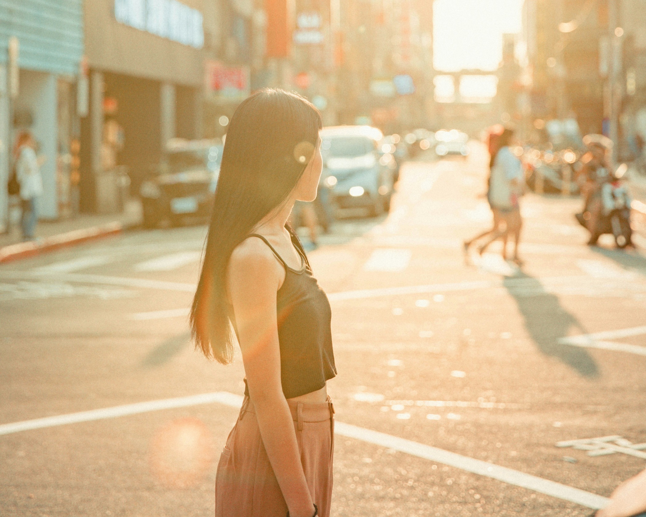A woman stands in the middle of a busy road