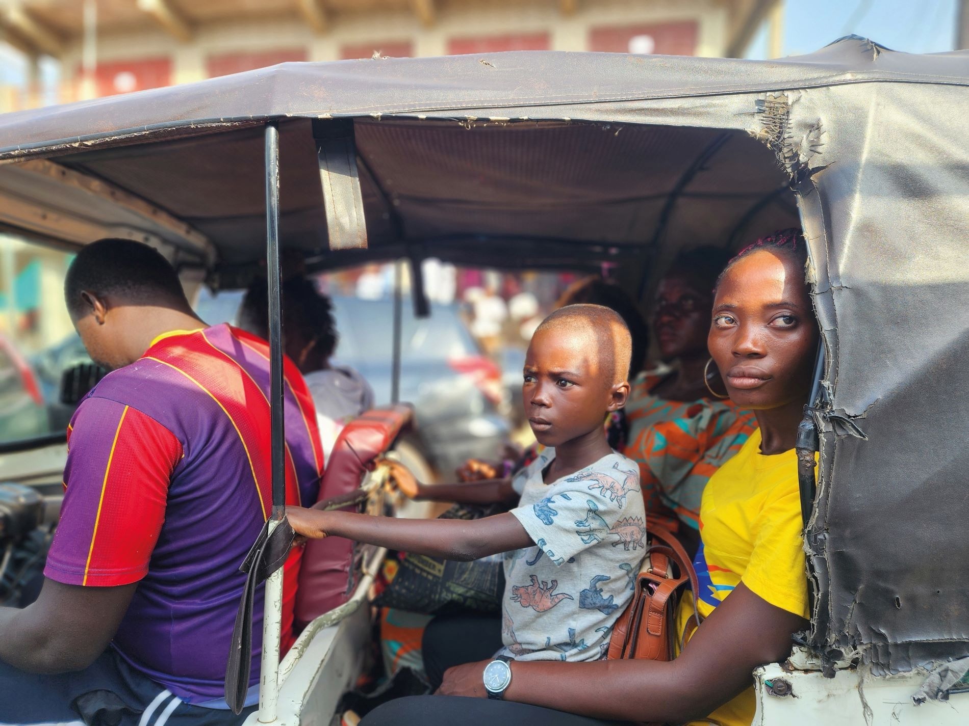 A boy and his mother travel in an auto-rickshaw in Freetown, Sierra Leone