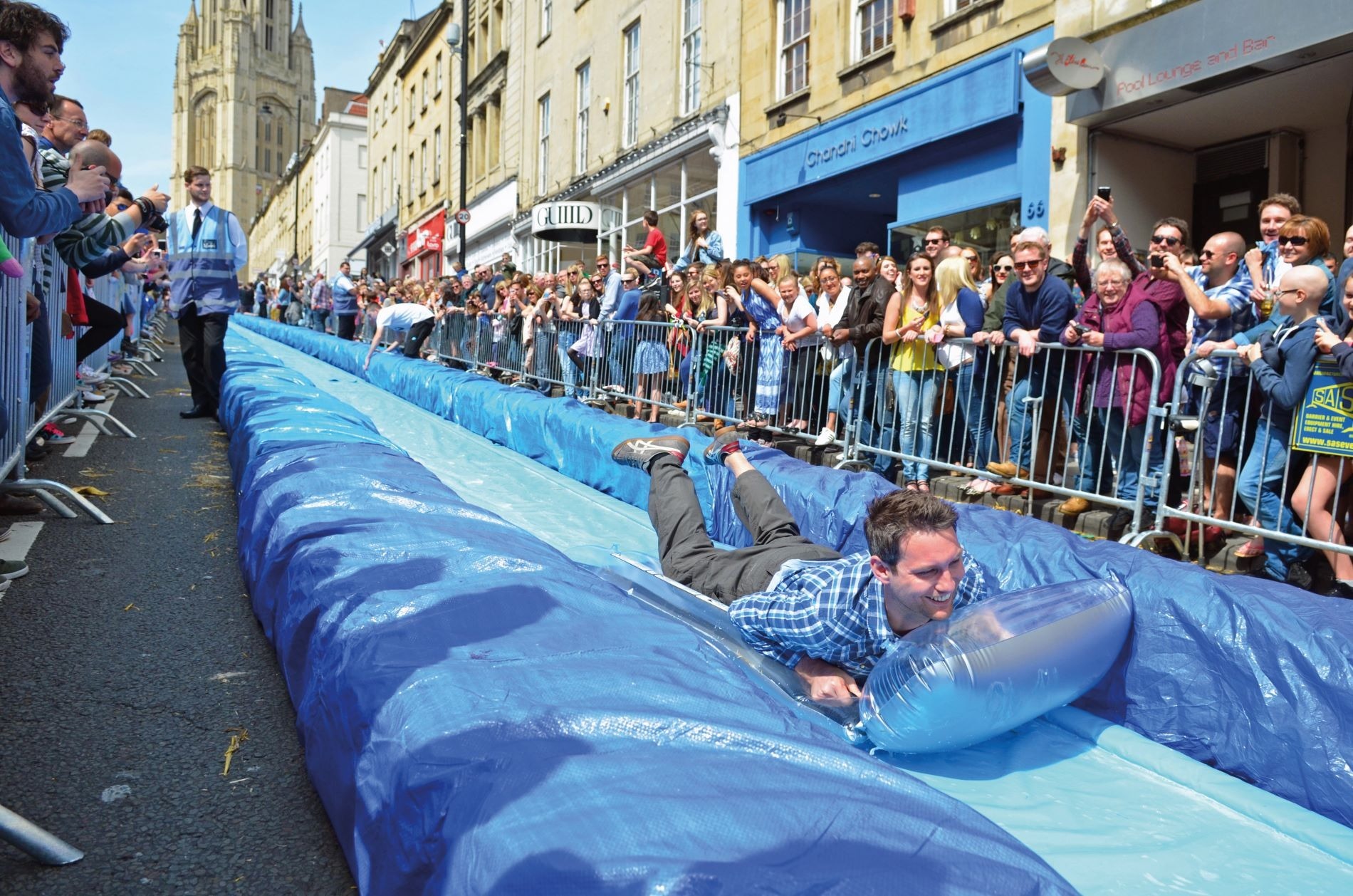 Adults play on a waterslide