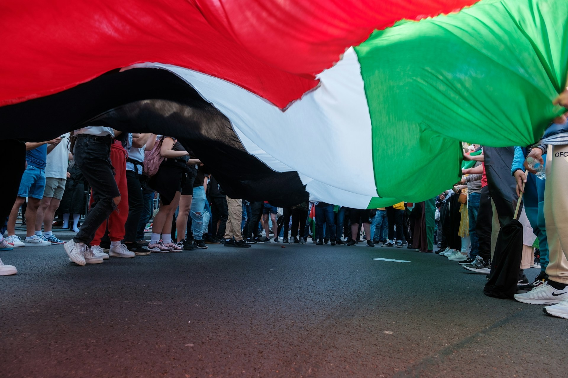 Protesters stand around a huge Palestinian flag during a protest in London