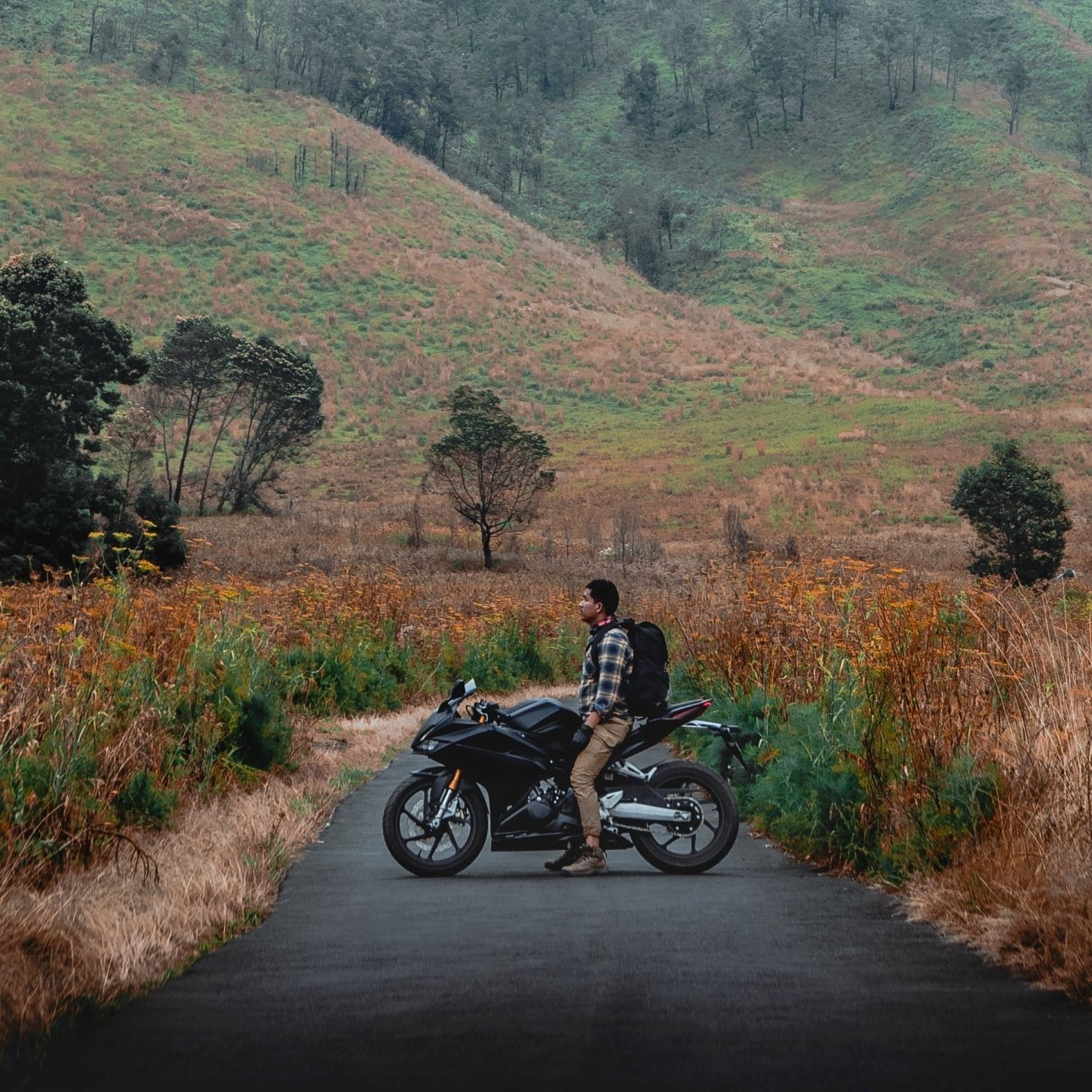 A man on a motorbike in the mountains